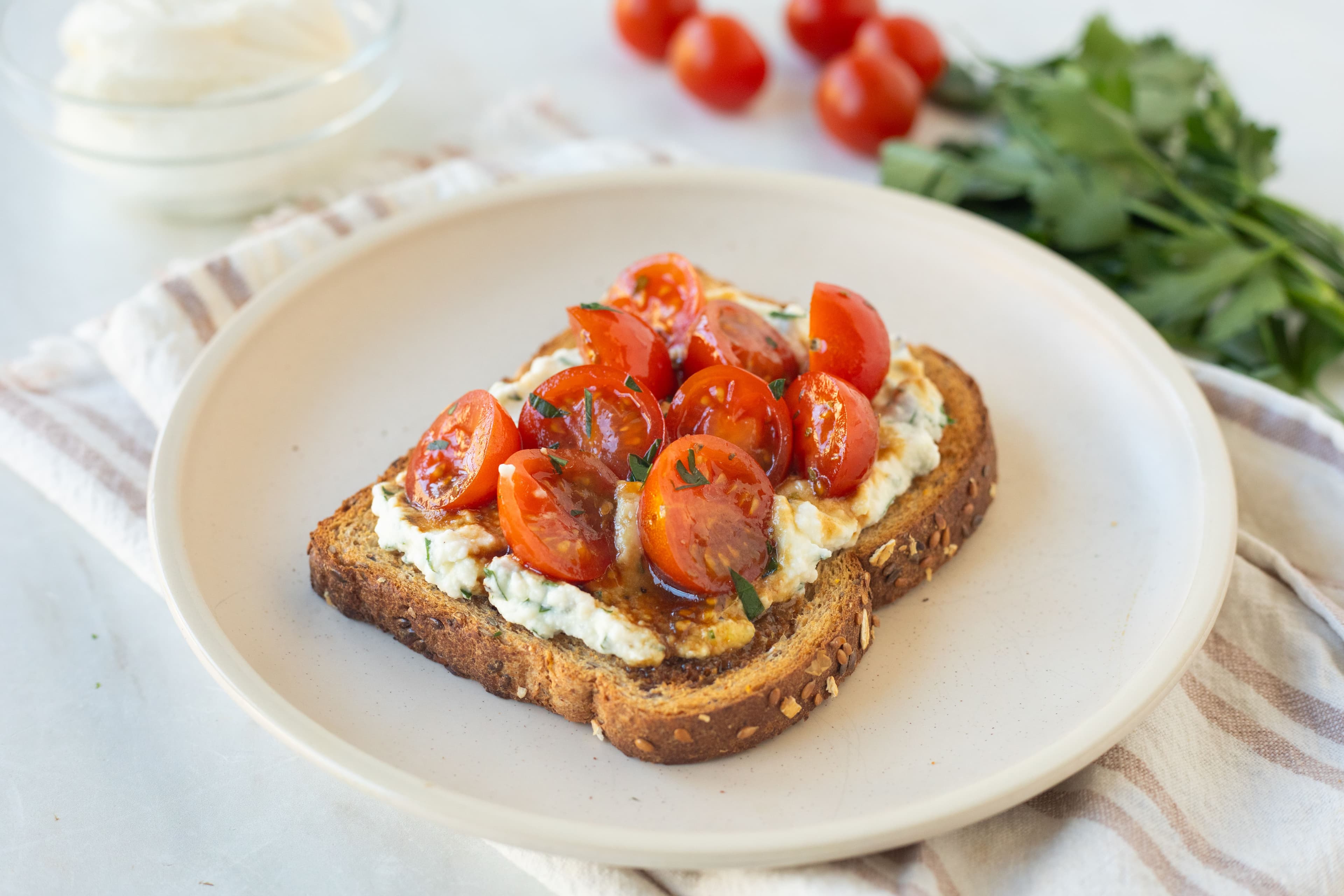 Tostada de desayuno con ricotta y tomate con hierbas